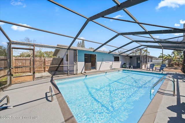 view of pool with glass enclosure, a fenced in pool, a patio area, and fence