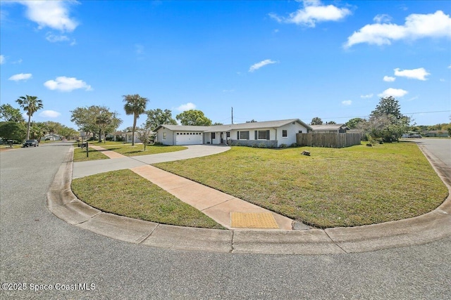 ranch-style house featuring a front lawn, an attached garage, driveway, and fence