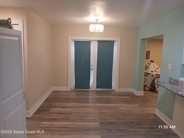 foyer featuring baseboards and wood finished floors