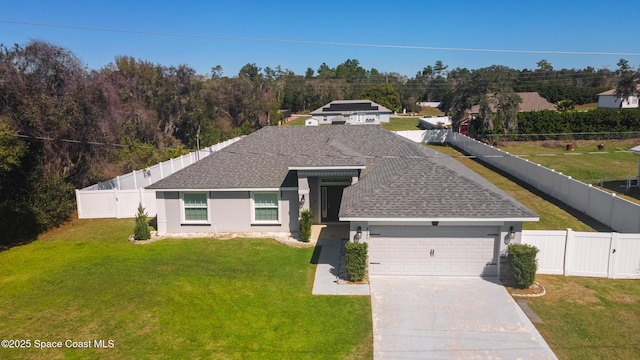 view of front facade with a fenced backyard, a shingled roof, a front lawn, and concrete driveway