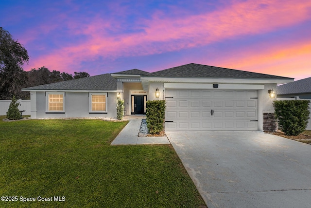 view of front facade with a garage, driveway, a shingled roof, a front yard, and stucco siding