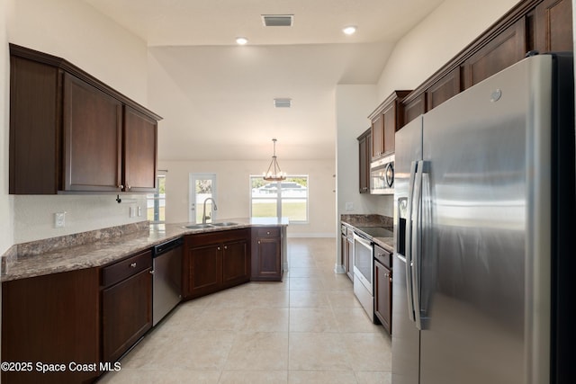 kitchen with stainless steel appliances, a sink, a peninsula, and dark brown cabinets