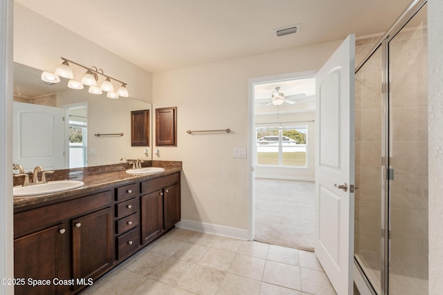 full bathroom featuring double vanity, a stall shower, a sink, and visible vents