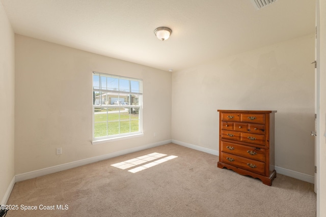 unfurnished room featuring carpet and baseboards