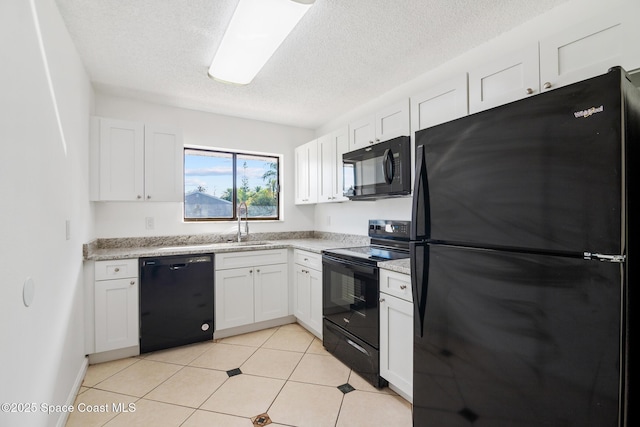 kitchen featuring white cabinets, a sink, a textured ceiling, light stone countertops, and black appliances