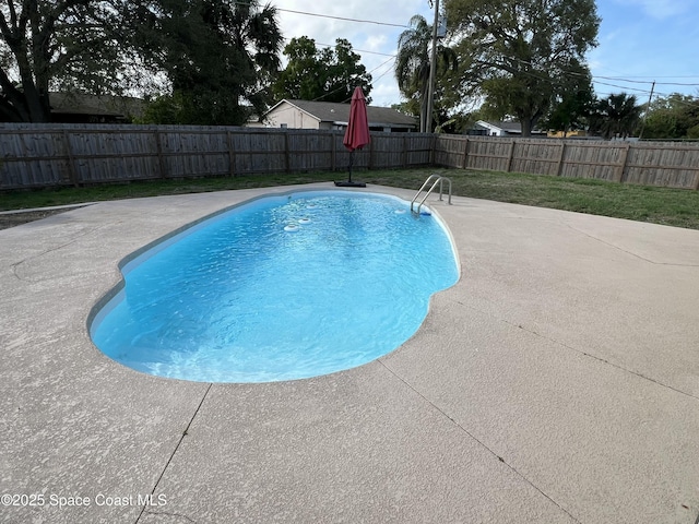 view of swimming pool with a fenced backyard, a lawn, a fenced in pool, and a patio