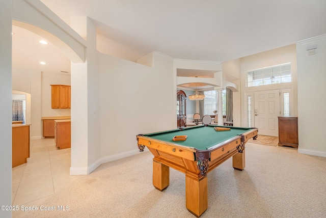 recreation room featuring recessed lighting, baseboards, arched walkways, and light colored carpet