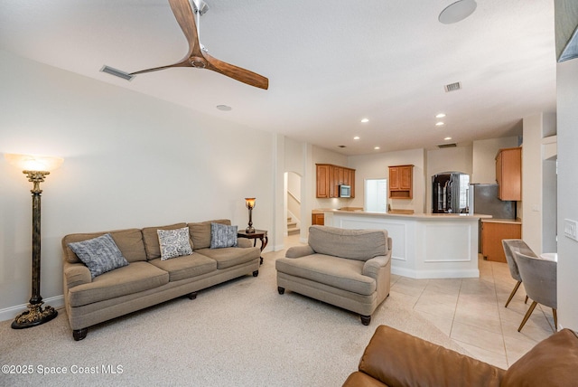 living room with stairs, ceiling fan, light tile patterned flooring, and visible vents