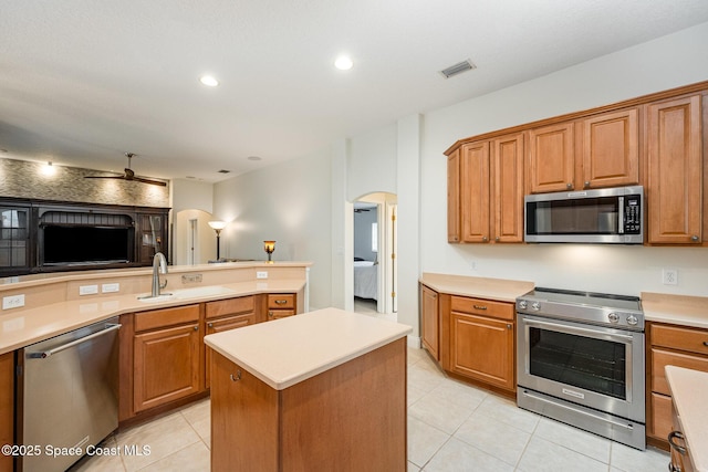 kitchen with stainless steel appliances, arched walkways, visible vents, and a sink