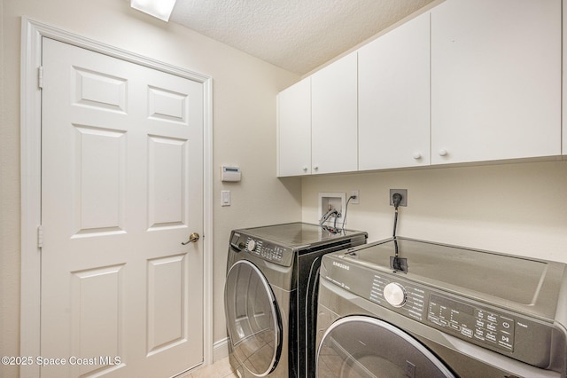 laundry area featuring cabinet space, independent washer and dryer, a textured ceiling, and light tile patterned floors