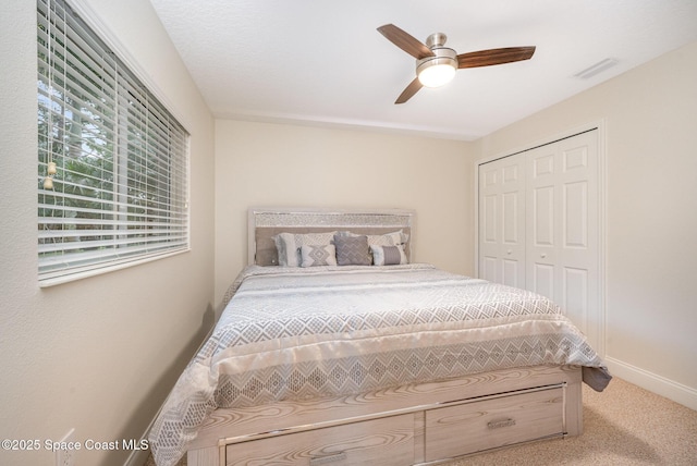 carpeted bedroom featuring a closet, visible vents, ceiling fan, and baseboards