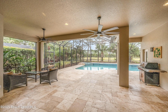 view of pool featuring a patio, a lanai, a pool with connected hot tub, a ceiling fan, and grilling area