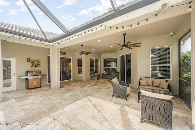 view of patio / terrace featuring glass enclosure, a grill, outdoor lounge area, and ceiling fan