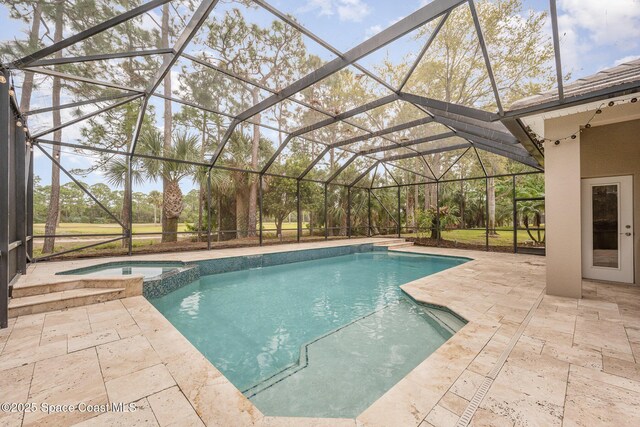 view of pool featuring a patio area, a lanai, and a pool with connected hot tub