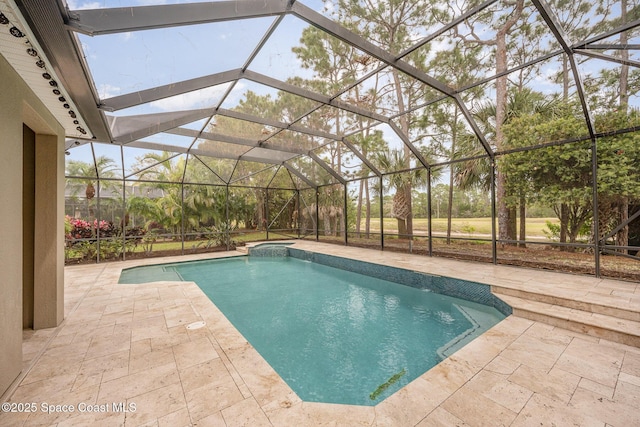 view of swimming pool featuring a pool with connected hot tub, a lanai, and a patio