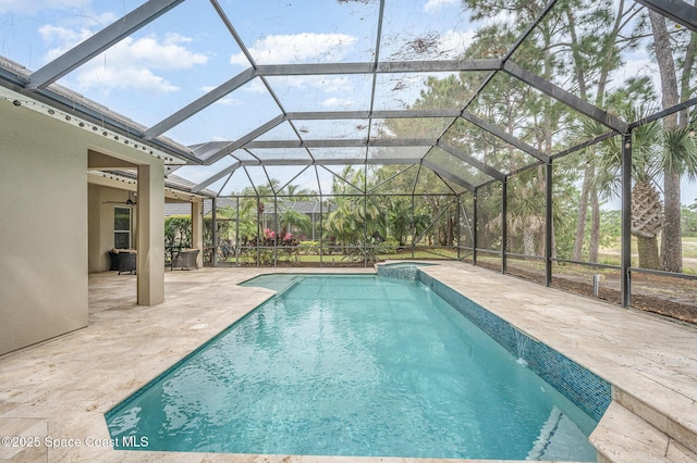 view of pool with a pool with connected hot tub, a patio area, and a lanai