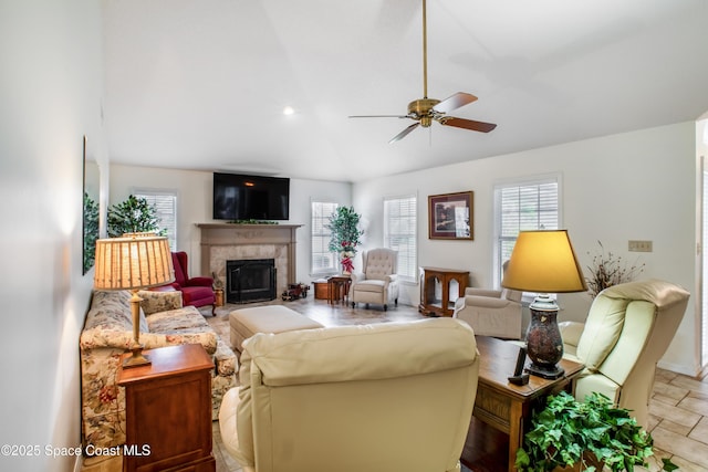 living room with ceiling fan, a fireplace, and stone finish floor