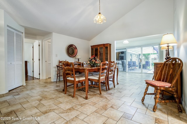 dining area with high vaulted ceiling