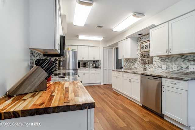 kitchen featuring visible vents, wood counters, appliances with stainless steel finishes, light wood-style floors, and a sink