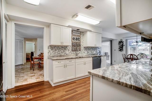 kitchen featuring visible vents, white cabinets, dishwashing machine, light wood-style flooring, and backsplash