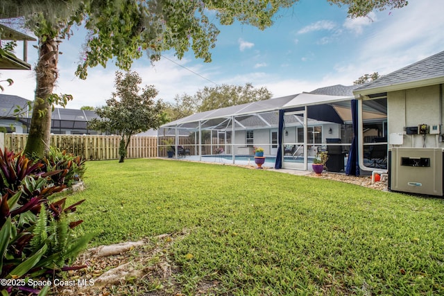 view of yard with a fenced backyard, a fenced in pool, and a lanai