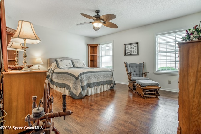 bedroom featuring a textured ceiling, wood finished floors, and baseboards