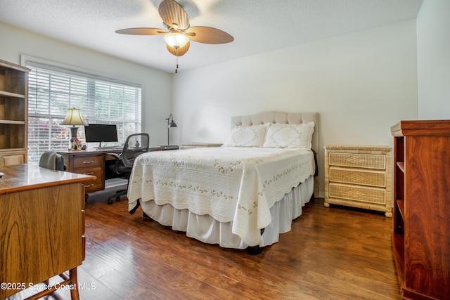 bedroom with dark wood-style floors, a textured ceiling, and a ceiling fan