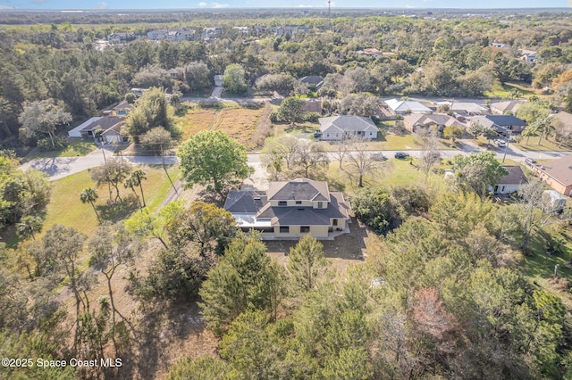 drone / aerial view featuring a residential view and a forest view