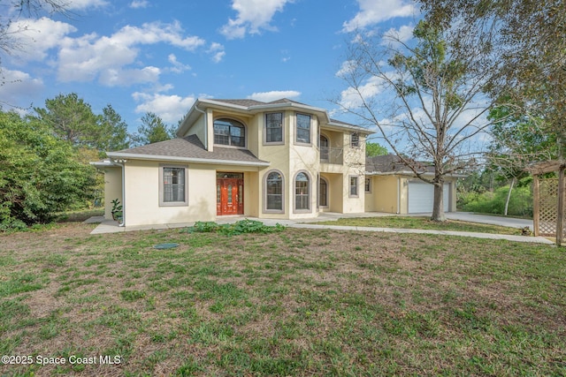 view of front of property featuring stucco siding, an attached garage, a balcony, and a front yard