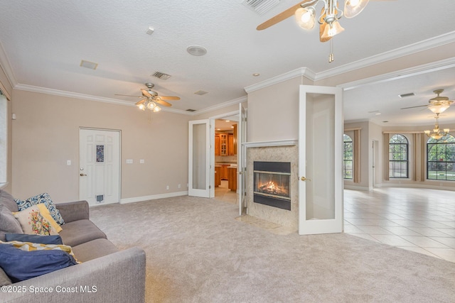 living room with light carpet, ornamental molding, a tiled fireplace, and visible vents