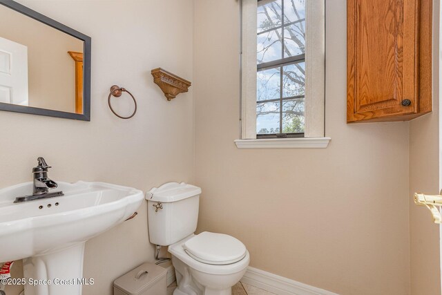 bathroom featuring toilet and baseboards