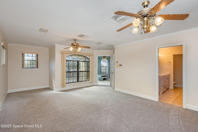 spare room featuring visible vents, crown molding, and light colored carpet