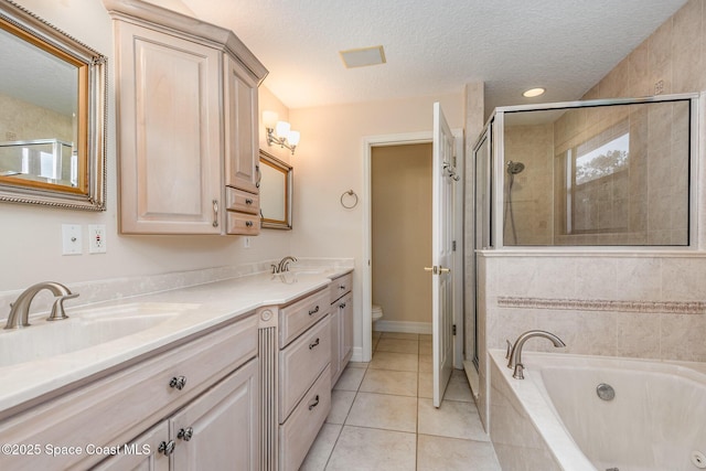 full bath featuring a textured ceiling, tile patterned flooring, a sink, a bath, and a stall shower