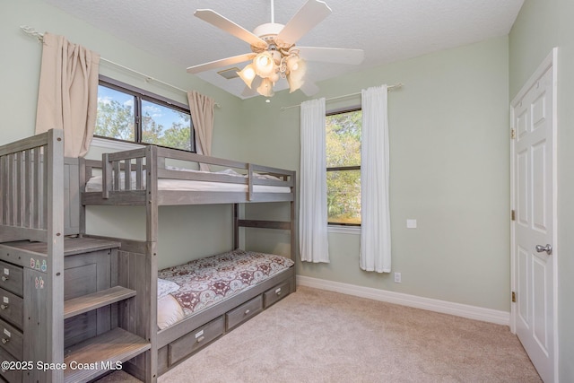 bedroom featuring carpet, ceiling fan, a textured ceiling, and baseboards