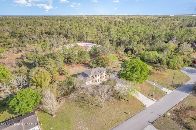 birds eye view of property featuring a forest view