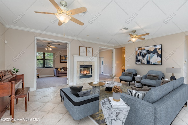 living area featuring light tile patterned floors, visible vents, crown molding, and a tile fireplace