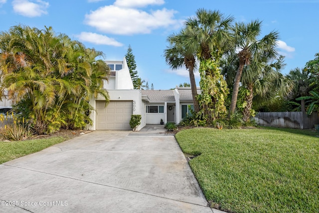 view of front of home featuring a garage, concrete driveway, fence, a front yard, and stucco siding