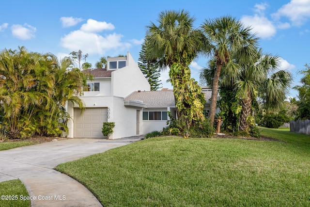 view of front of house featuring a garage, concrete driveway, a front yard, and stucco siding