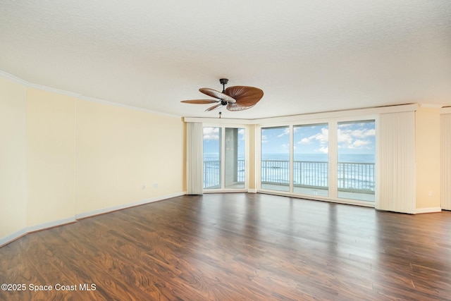 empty room with ornamental molding, a textured ceiling, wood finished floors, baseboards, and ceiling fan