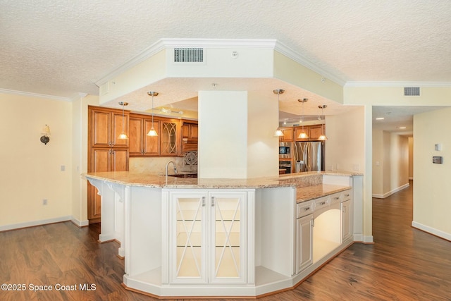 kitchen with stainless steel appliances, glass insert cabinets, visible vents, and dark wood finished floors