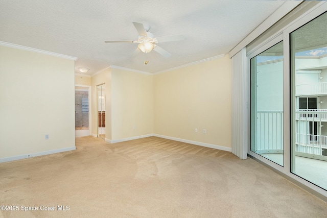 spare room with crown molding, a ceiling fan, baseboards, and light carpet