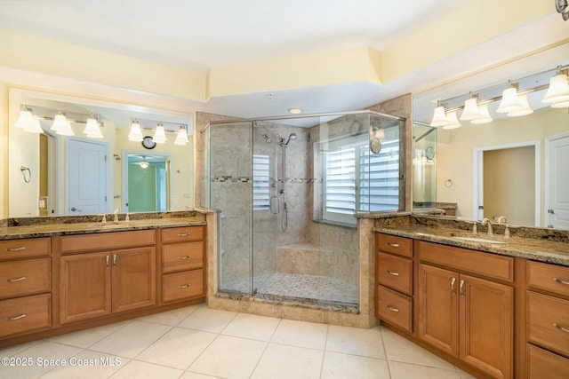 bathroom featuring a shower stall, two vanities, and a sink