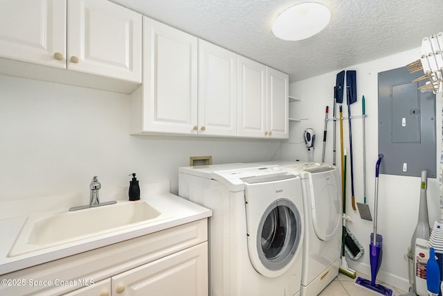 laundry area featuring washer and clothes dryer, a sink, electric panel, a textured ceiling, and cabinet space