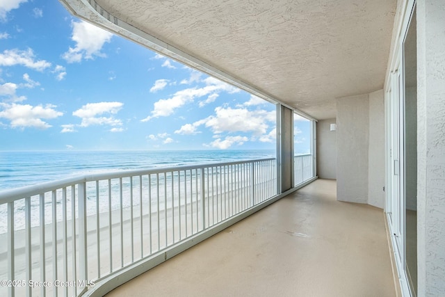 balcony featuring a beach view and a water view