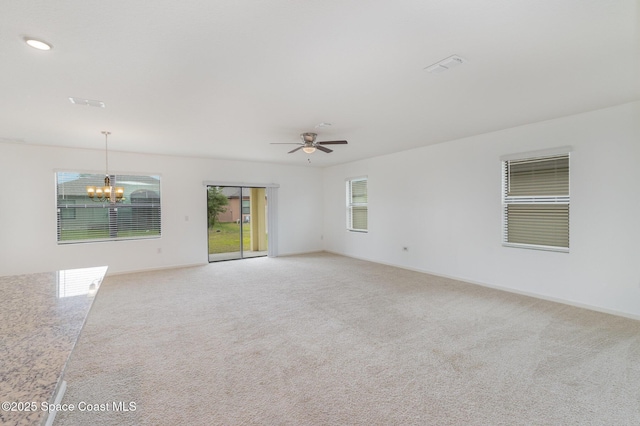 empty room with a chandelier, carpet flooring, a ceiling fan, and baseboards