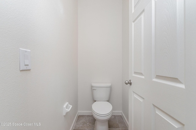 bathroom featuring baseboards, toilet, and tile patterned floors