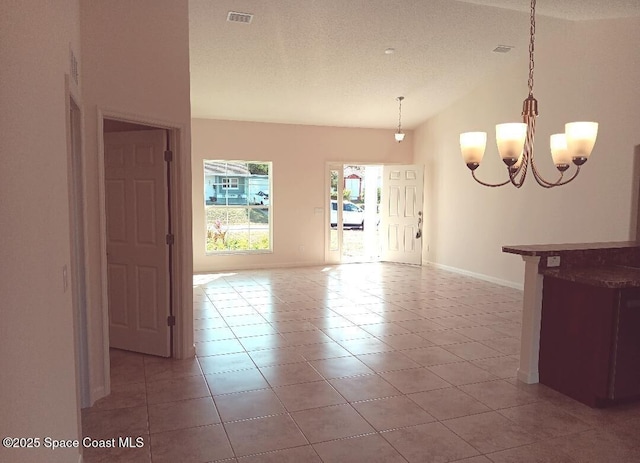 spare room with light tile patterned floors, baseboards, visible vents, vaulted ceiling, and a chandelier