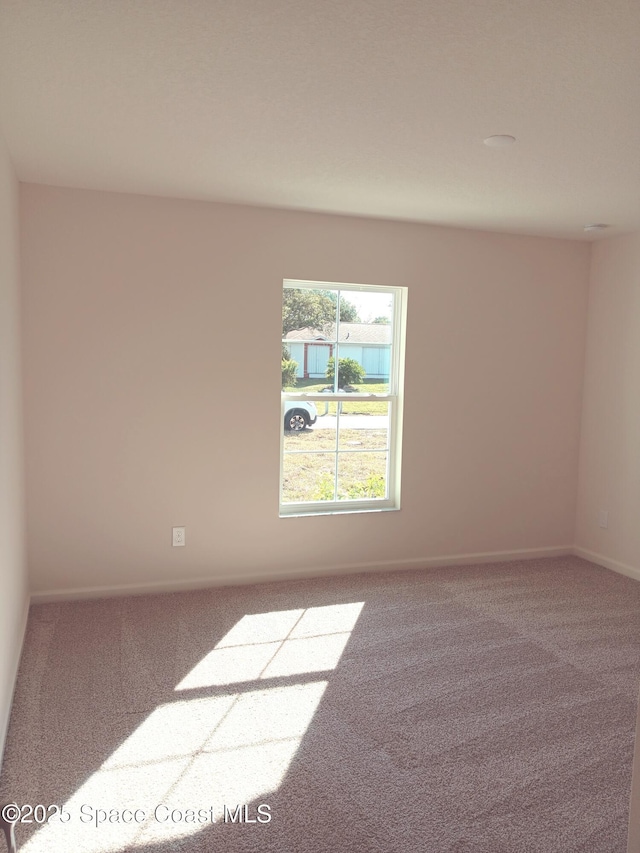 empty room featuring carpet flooring and baseboards