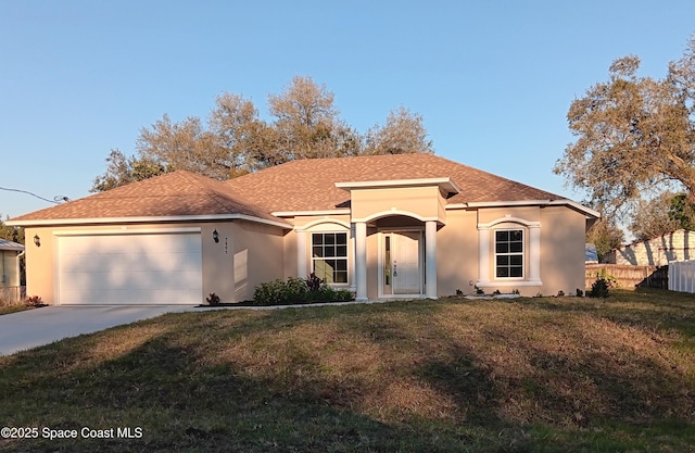 mediterranean / spanish house featuring an attached garage, fence, concrete driveway, stucco siding, and a front yard