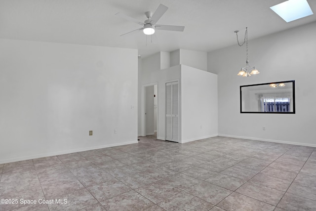 unfurnished room featuring ceiling fan, high vaulted ceiling, a skylight, and baseboards